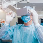 Doctor in a surgical room with virtual reality glasses on the background of the real operation. Doctor in a surgical room with virtual reality glasses on the background of the real operation. Modern technologies